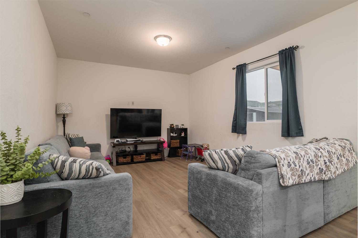 1945 East Gum Avenue Reedley, CA 93654 - Photo 8 of 31 a living room with furniture and a flat screen tv