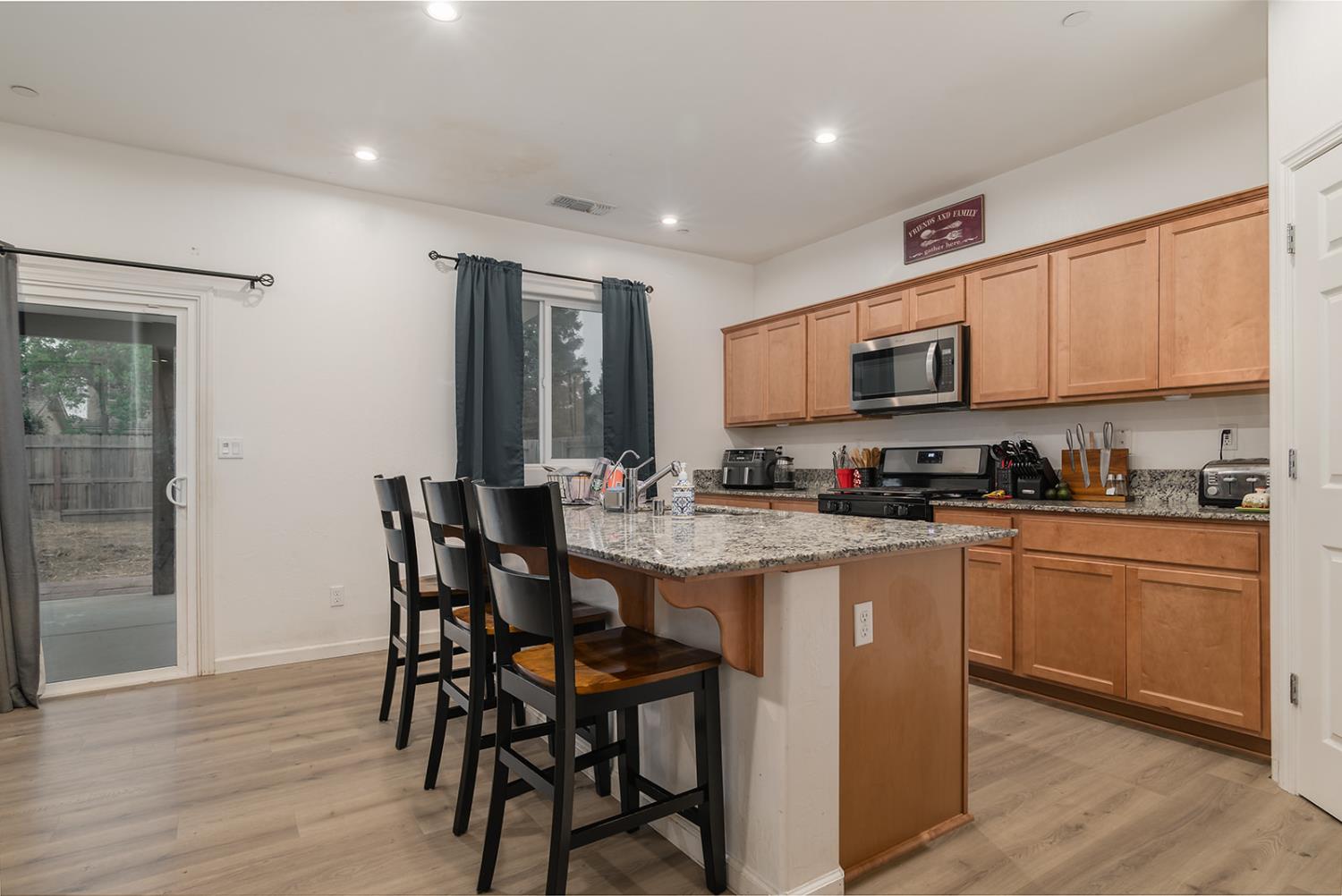1945 East Gum Avenue Reedley, CA 93654 - Photo 9 of 31 a kitchen with stainless steel appliances granite countertop a table chairs sink and cabinets