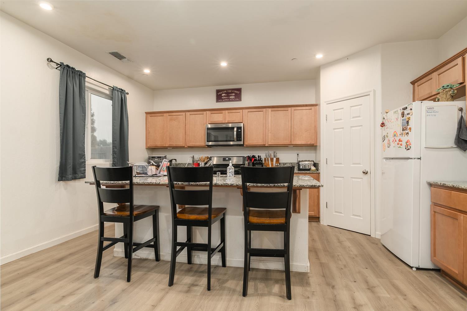 1945 East Gum Avenue Reedley, CA 93654 - Photo 10 of 31 a kitchen with a refrigerator and a dining table