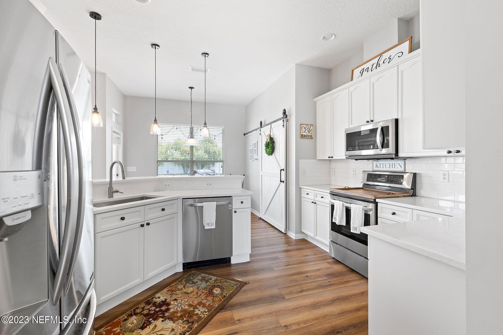 293 Porta Rosa Circle St. Augustine, FL 32092 - Photo 9 of 37 a kitchen with white cabinets stainless steel appliances a sink and a center