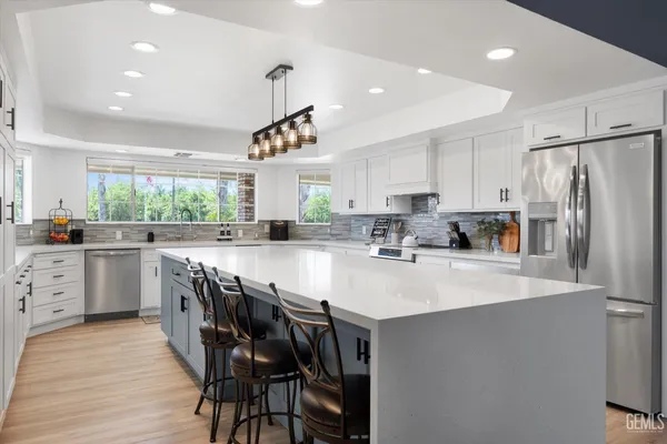 a kitchen with granite countertop a sink stainless steel appliances and cabinets