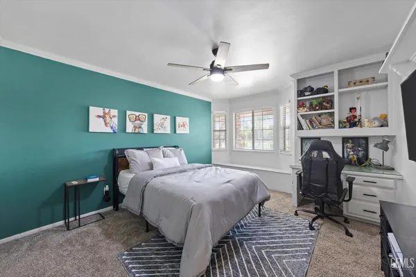 a spacious bedroom with a bed and dresser with wooden floor