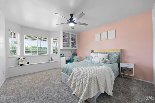 a spacious bedroom with a bed and a chandelier