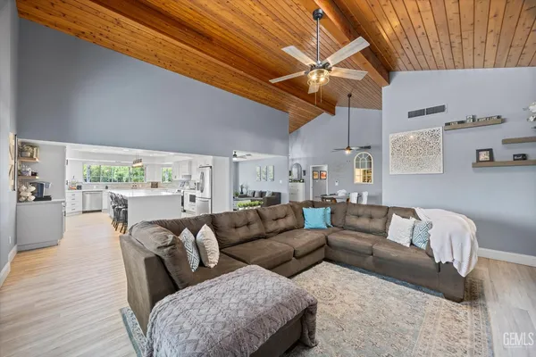 a kitchen with stainless steel appliances granite countertop a table chairs sink refrigerator and cabinets