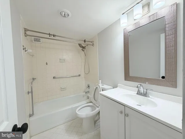 a bathroom with a granite countertop sink a toilet and shower