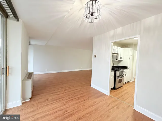 wooden floor in an empty room with a chandelier