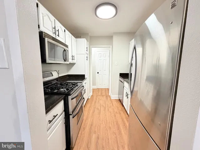 a kitchen with stainless steel appliances granite countertop a refrigerator and a stove