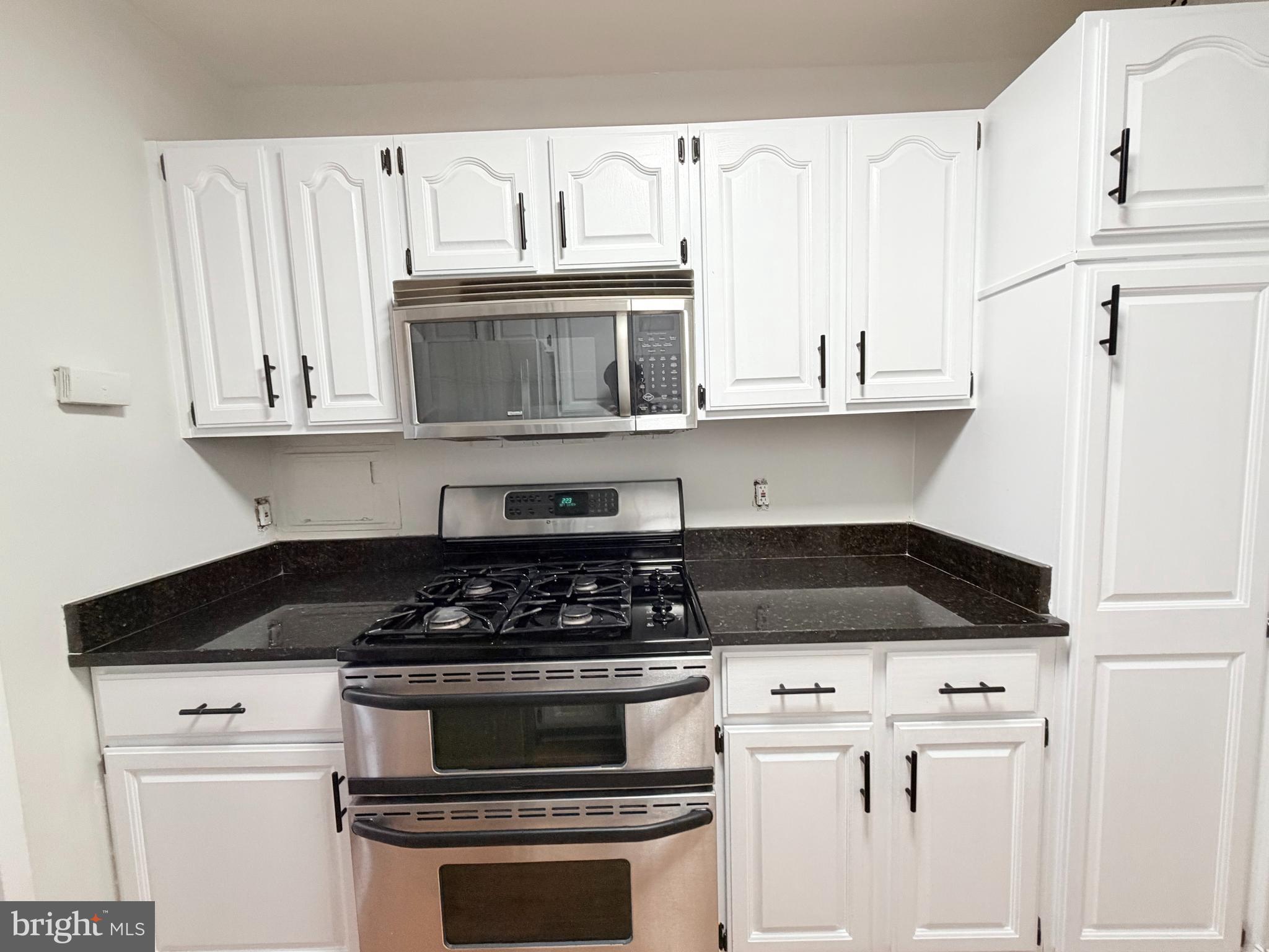 301 North Beauregard Street, Unit 703 Alexandria, VA 22312 - Photo 8 of 16 a kitchen with white cabinets and appliances