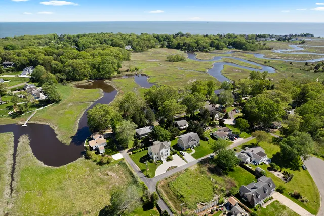 a view of a lake with a yard and mountain view in back