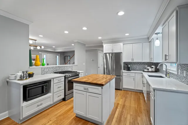 a kitchen with stainless steel appliances granite countertop a stove a sink and a refrigerator