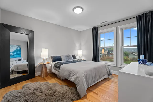 a bedroom with a bed and large windows