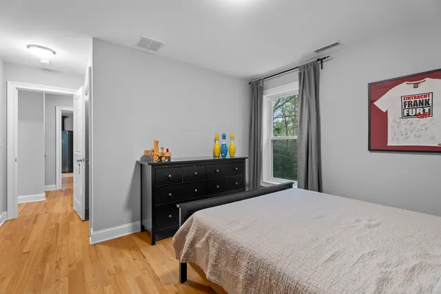 a bedroom with a bed and a mirror on dresser