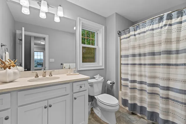 a bathroom with a sink a toilet a mirror a shower and a bathtub