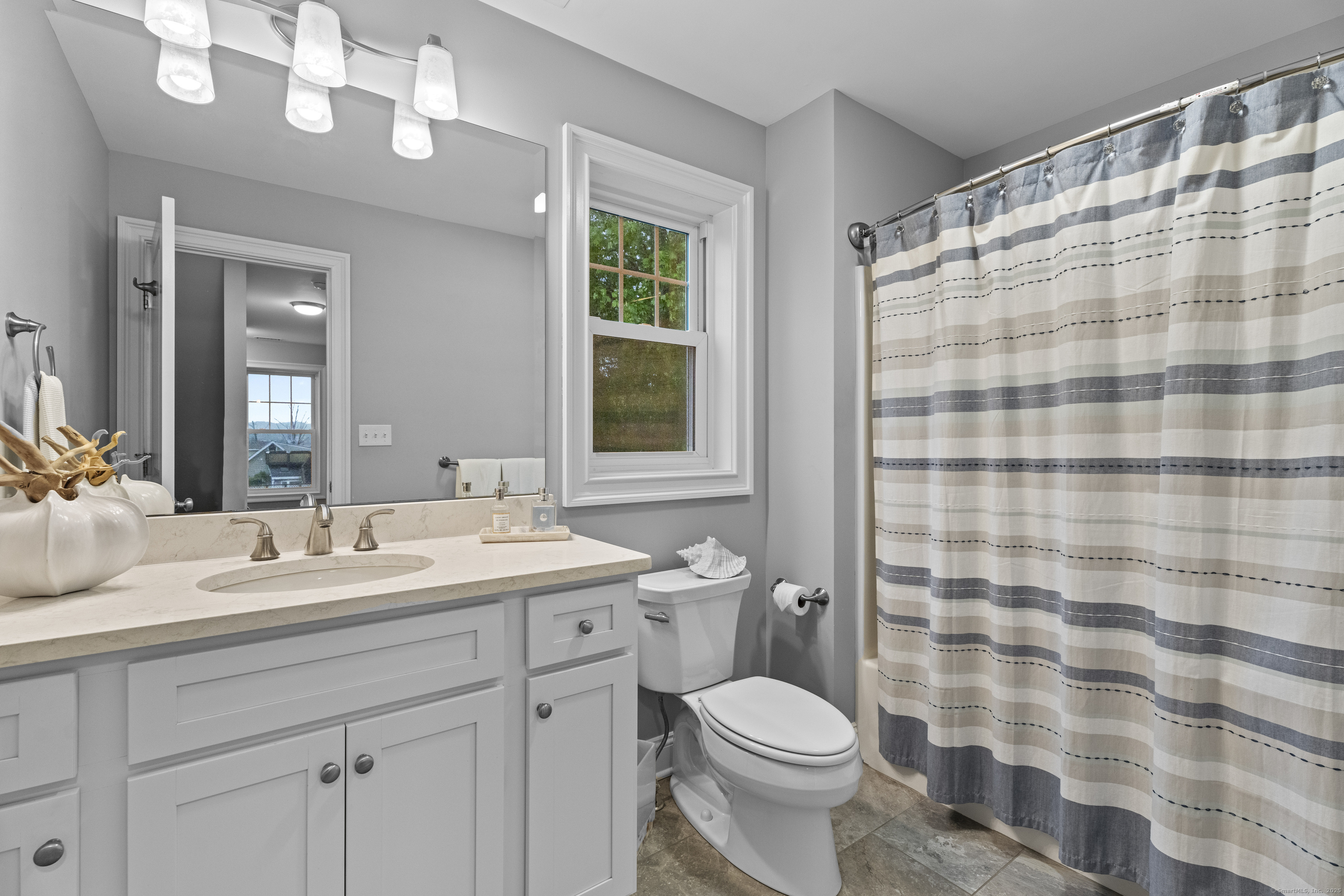 3 Arrowhead Road Madison, CT 06443 - Photo 28 of 40 a bathroom with a sink a toilet a mirror a shower and a bathtub