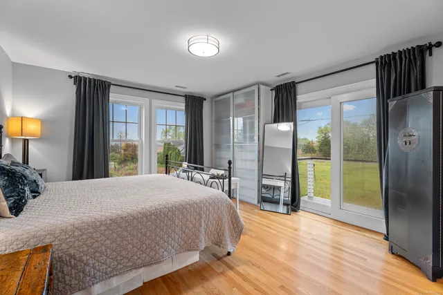 a bedroom with a bed and a large window with balcony view