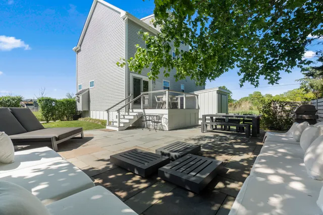 a view of backyard of house with seating area