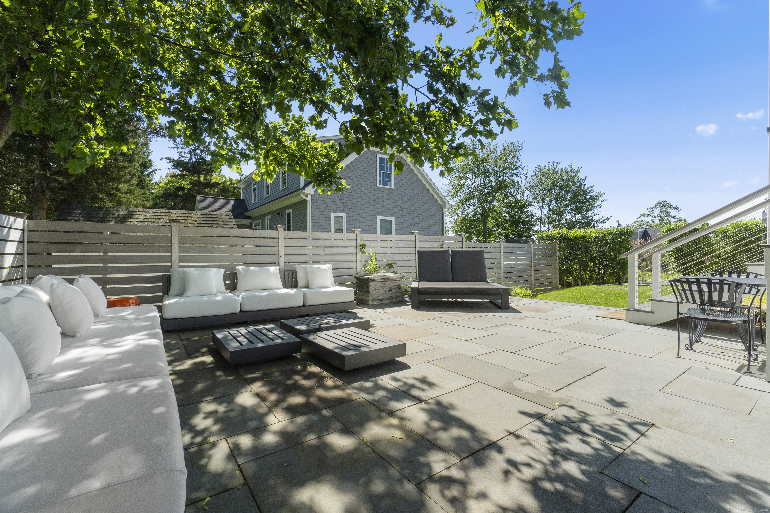 3 Arrowhead Road Madison, CT 06443 - Photo 7 of 40 a view of a patio with couches and a table and chairs with wooden fence and plants