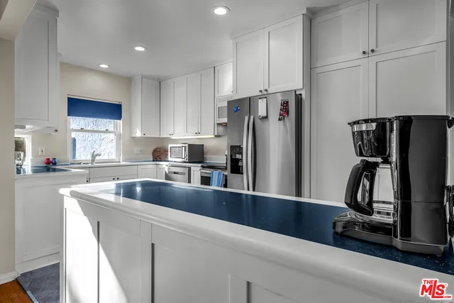 a kitchen with stainless steel appliances granite countertop a refrigerator a stove a sink and dishwasher