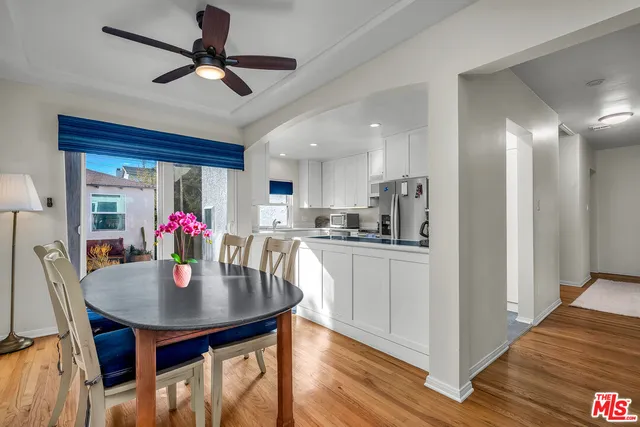 a kitchen with a dining table chairs and wooden floor