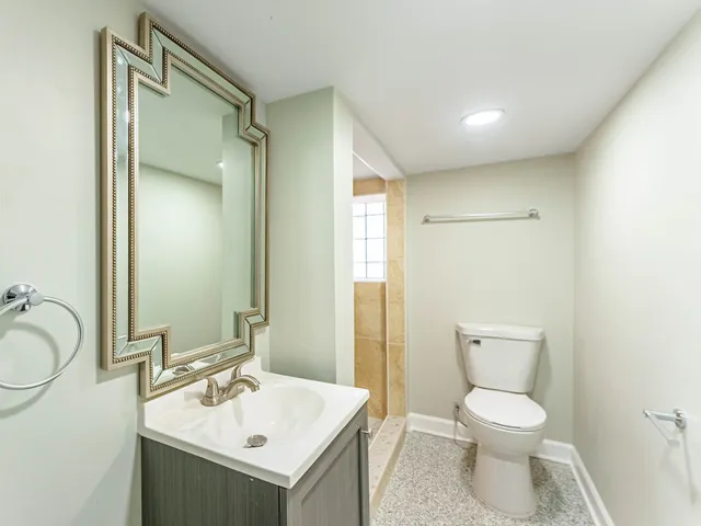 a bathroom with a toilet sink and mirror