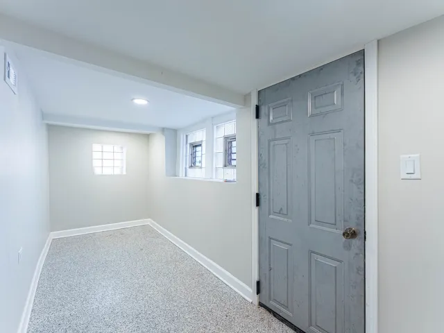 a view of an empty room with closet and a window