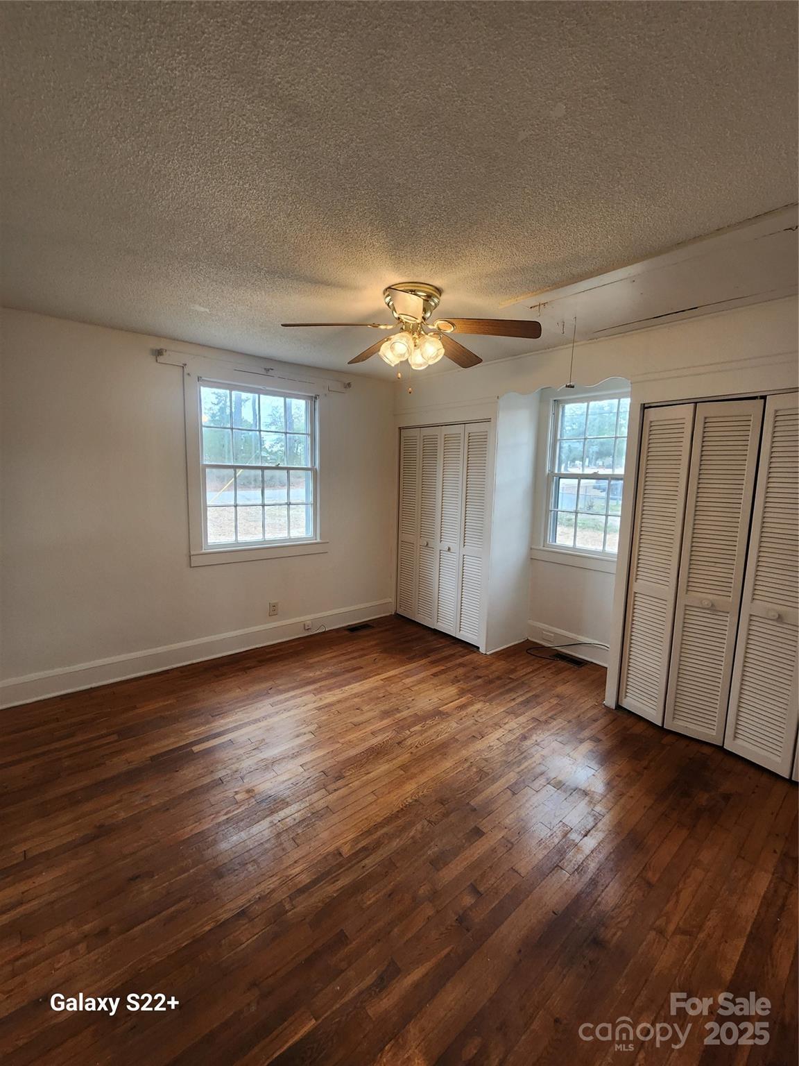 305 Louise Avenue Rockingham, NC 28379 - Photo 12 of 20 an empty room with wooden floor and windows