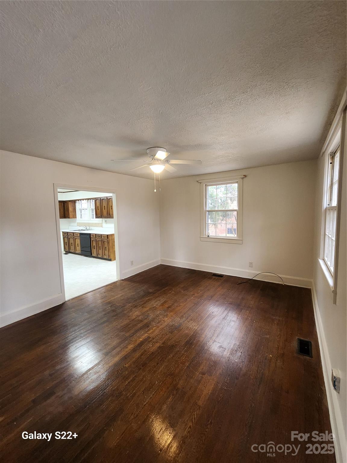 305 Louise Avenue Rockingham, NC 28379 - Photo 4 of 20 an empty room with wooden floor and windows