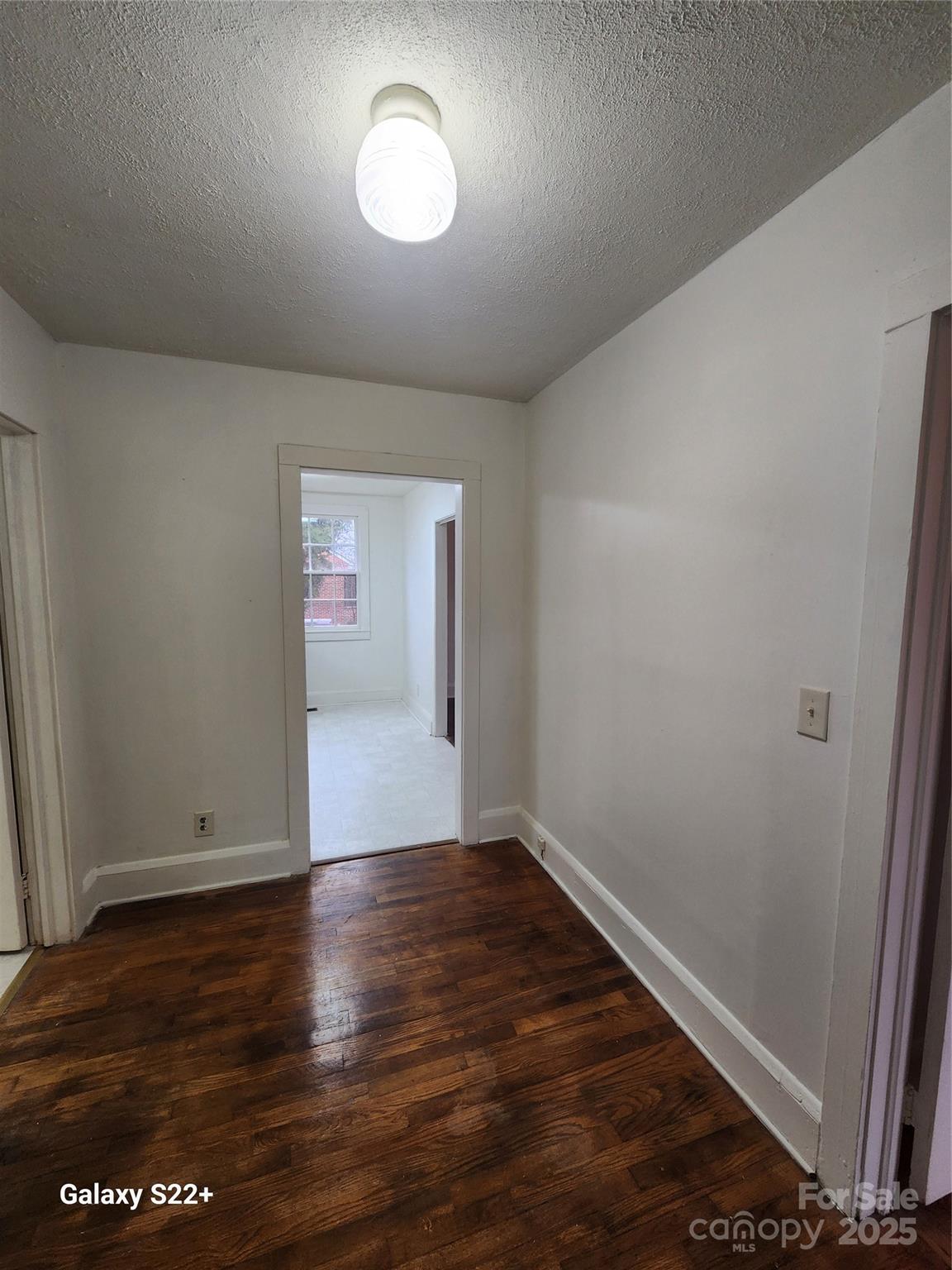 305 Louise Avenue Rockingham, NC 28379 - Photo 9 of 20 an empty room with wooden floor and windows