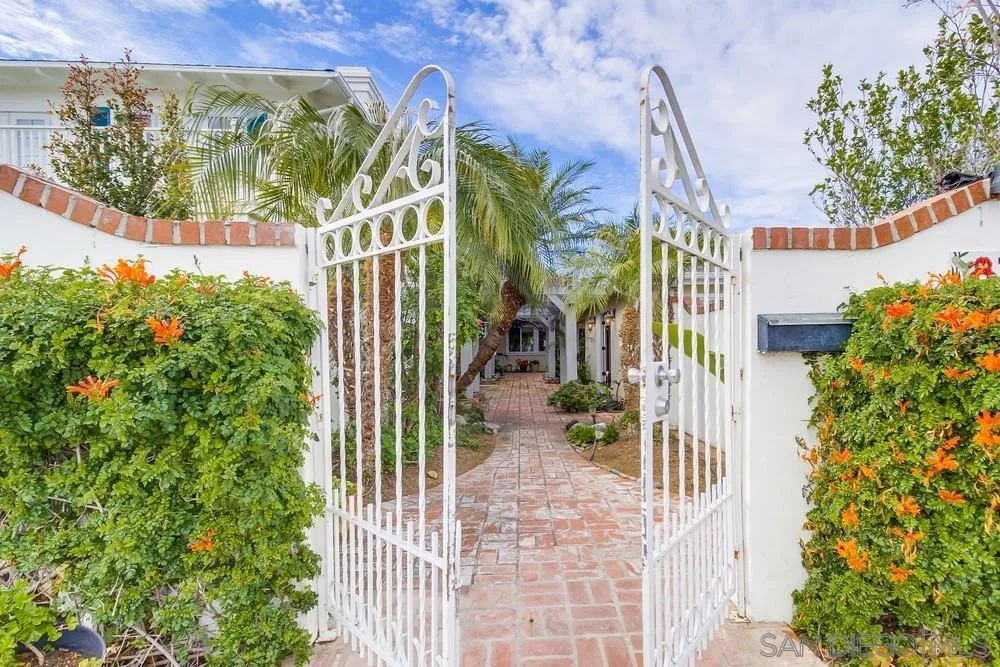 a view of a house with a small yard and flower plants