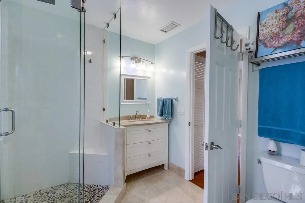 754 A Avenue Coronado, CA 92118 - Photo 17 of 25 a bathroom with a granite countertop sink a mirror and a shower