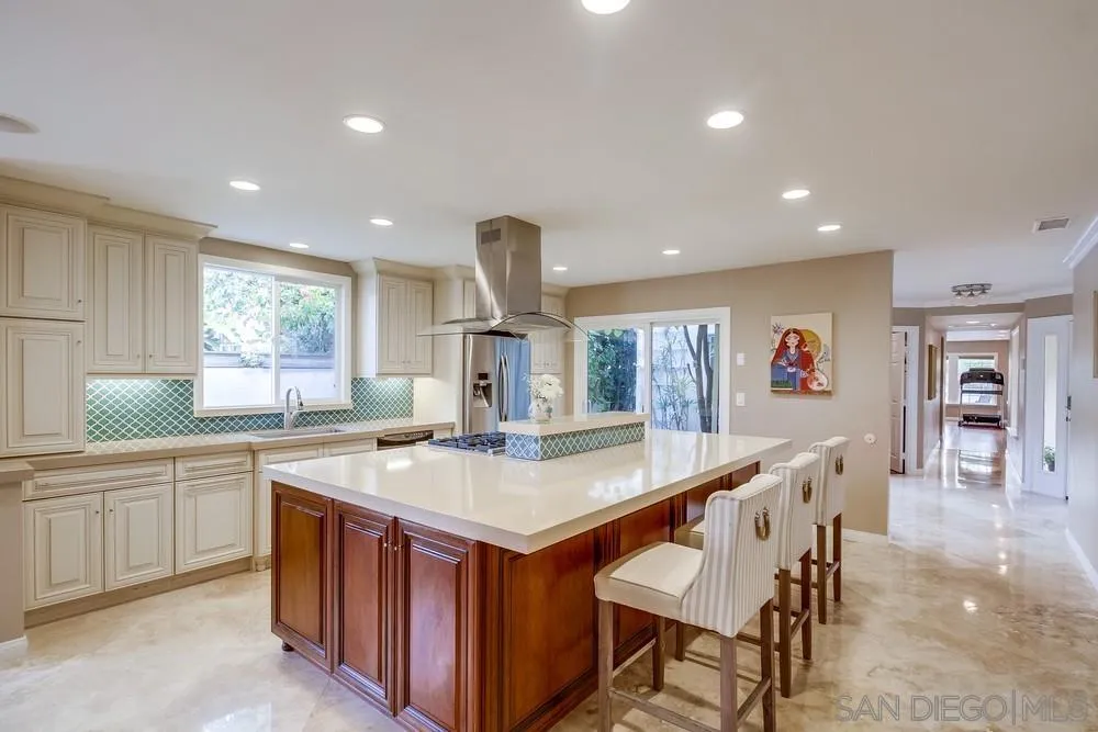 754 A Avenue Coronado, CA 92118 - Photo 9 of 25 a large kitchen with stainless steel appliances a sink table and chairs