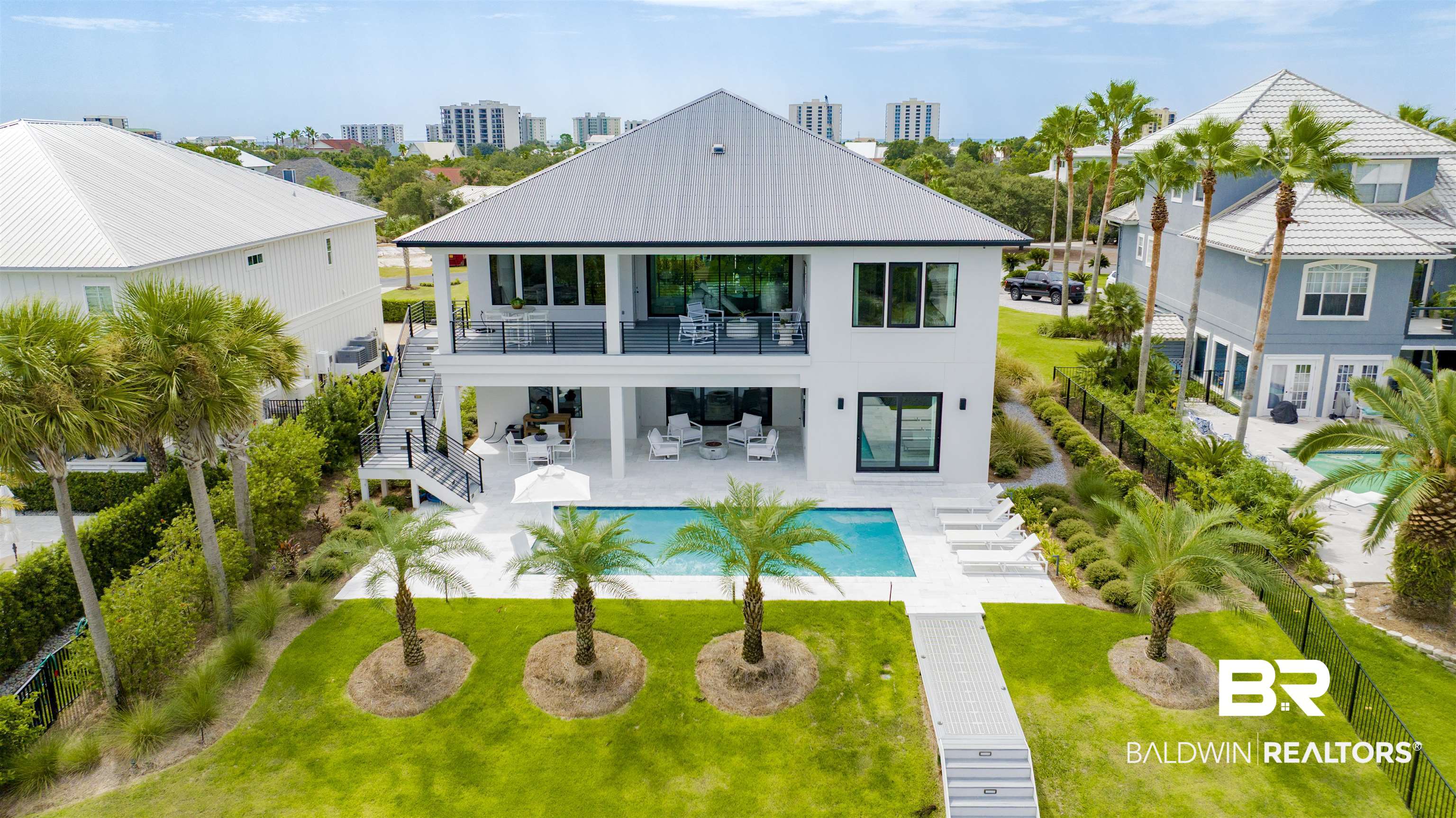 30239 Canal Court Orange Beach, AL 36561 - Photo 6 of 70 Rear view of property featuring a patio area, stairway, a lawn, an outdoor pool, and a balcony
