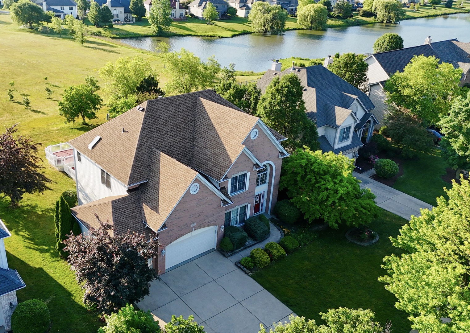 an aerial view of a house with a garden and lake view