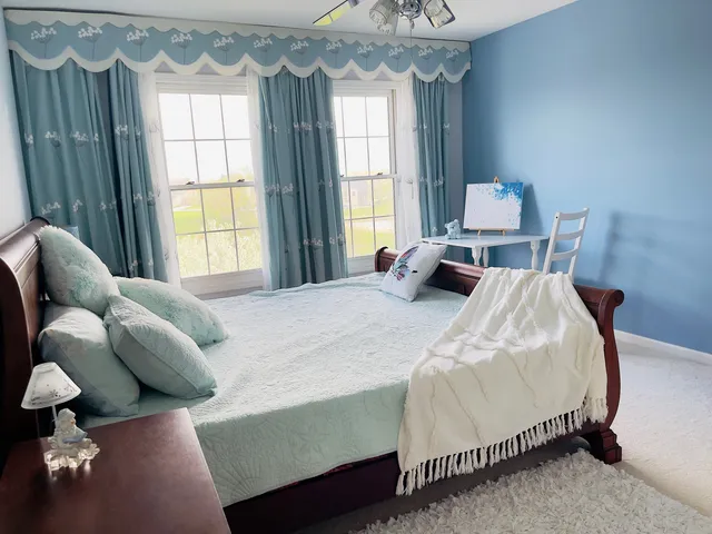 a bedroom with a bed a dresser and a window