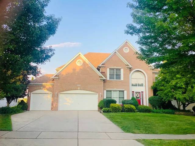 a view of a white house with a big yard and large trees