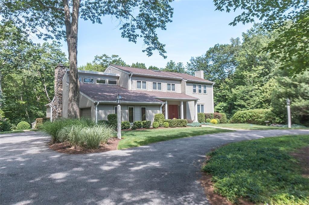 a view of a big house with a big yard and large trees