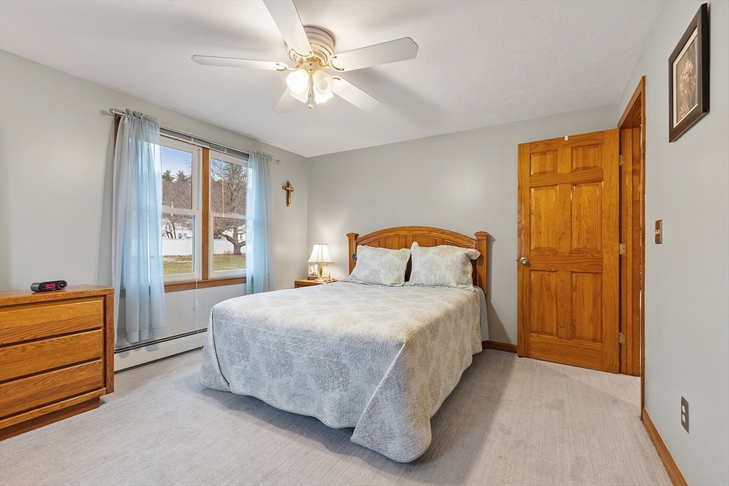 27 Lancaster Road Shirley, MA 01464 - Photo 17 of 41 a bedroom with a bed and a chandelier