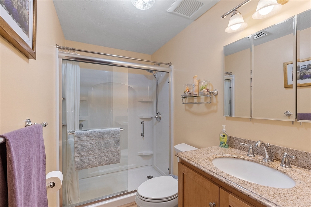 27 Lancaster Road Shirley, MA 01464 - Photo 22 of 41 a bathroom with a granite countertop sink toilet mirror and shower