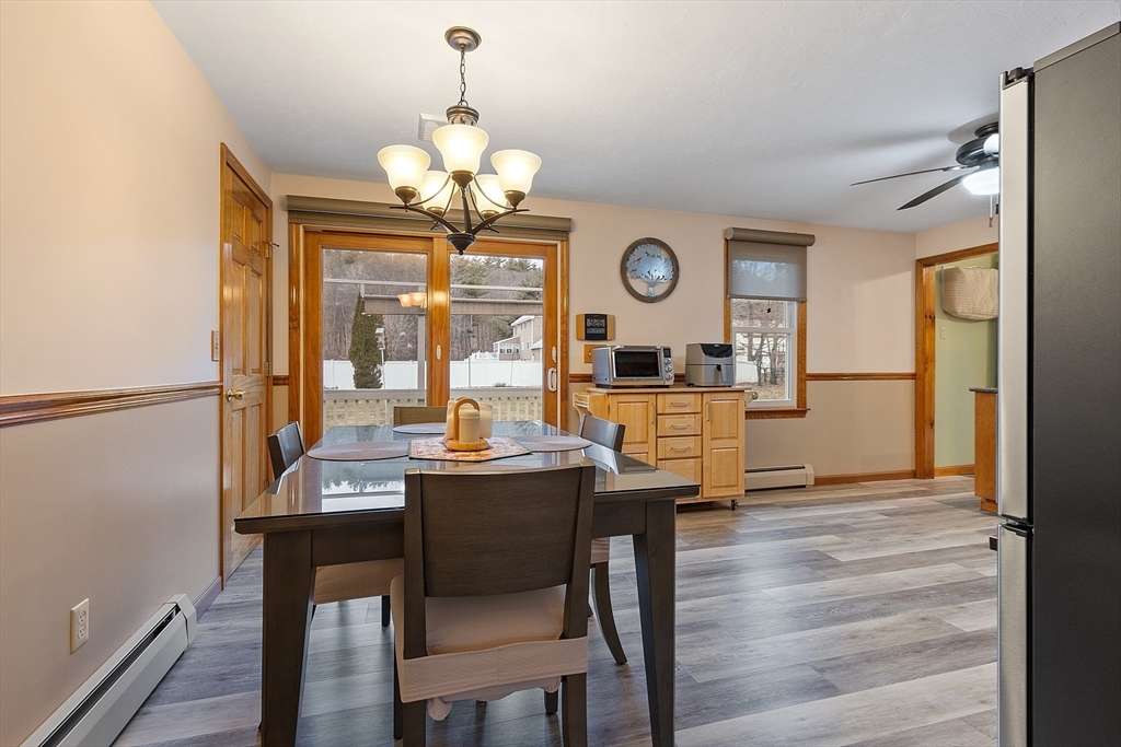 27 Lancaster Road Shirley, MA 01464 - Photo 10 of 41 a dining room with wooden floor a chandelier a wooden table and chairs