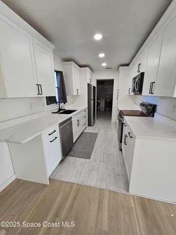 a view of a kitchen with furniture and wooden floor