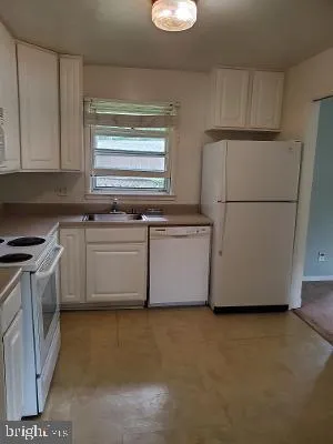 a kitchen with stainless steel appliances granite countertop a sink a stove a refrigerator with grey cabinets