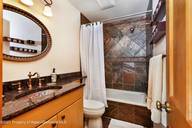 a bathroom with a sink a toilet a mirror and shower
