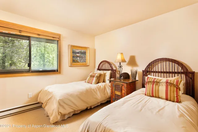 a bedroom with two beds and a large window