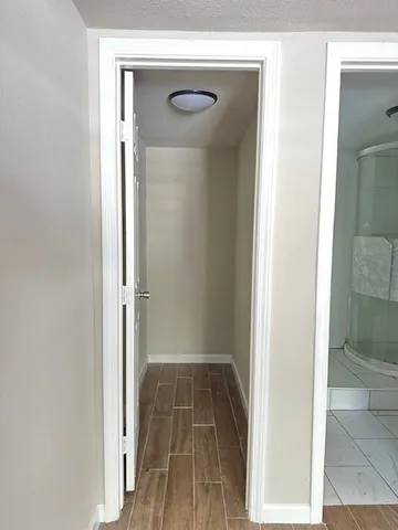 a view of a hallway with wooden floor