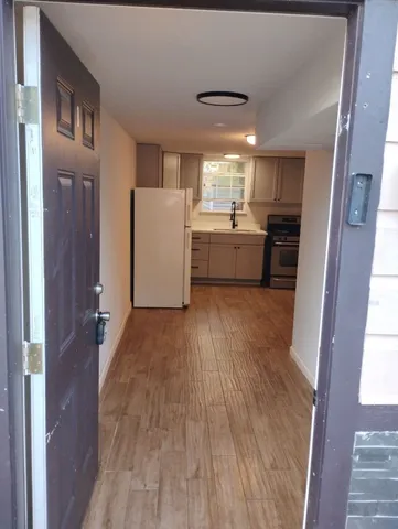 a view of a kitchen with wooden floor and electronic appliances
