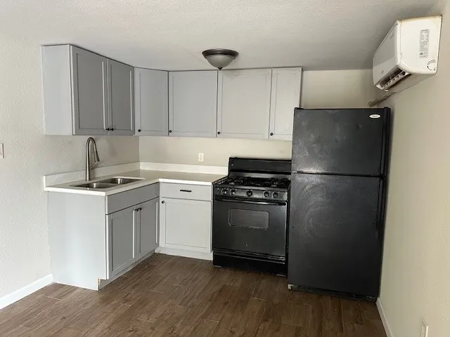 a kitchen with a refrigerator sink and cabinets