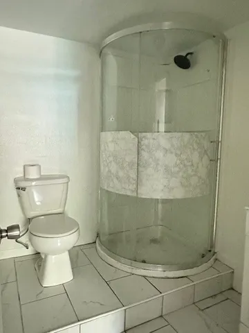 a bathroom with a toilet and a shower