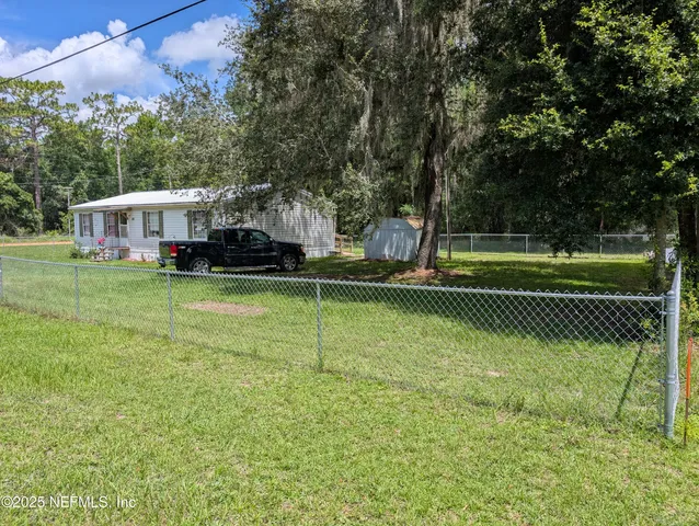 a view of a house with a big yard and sitting area