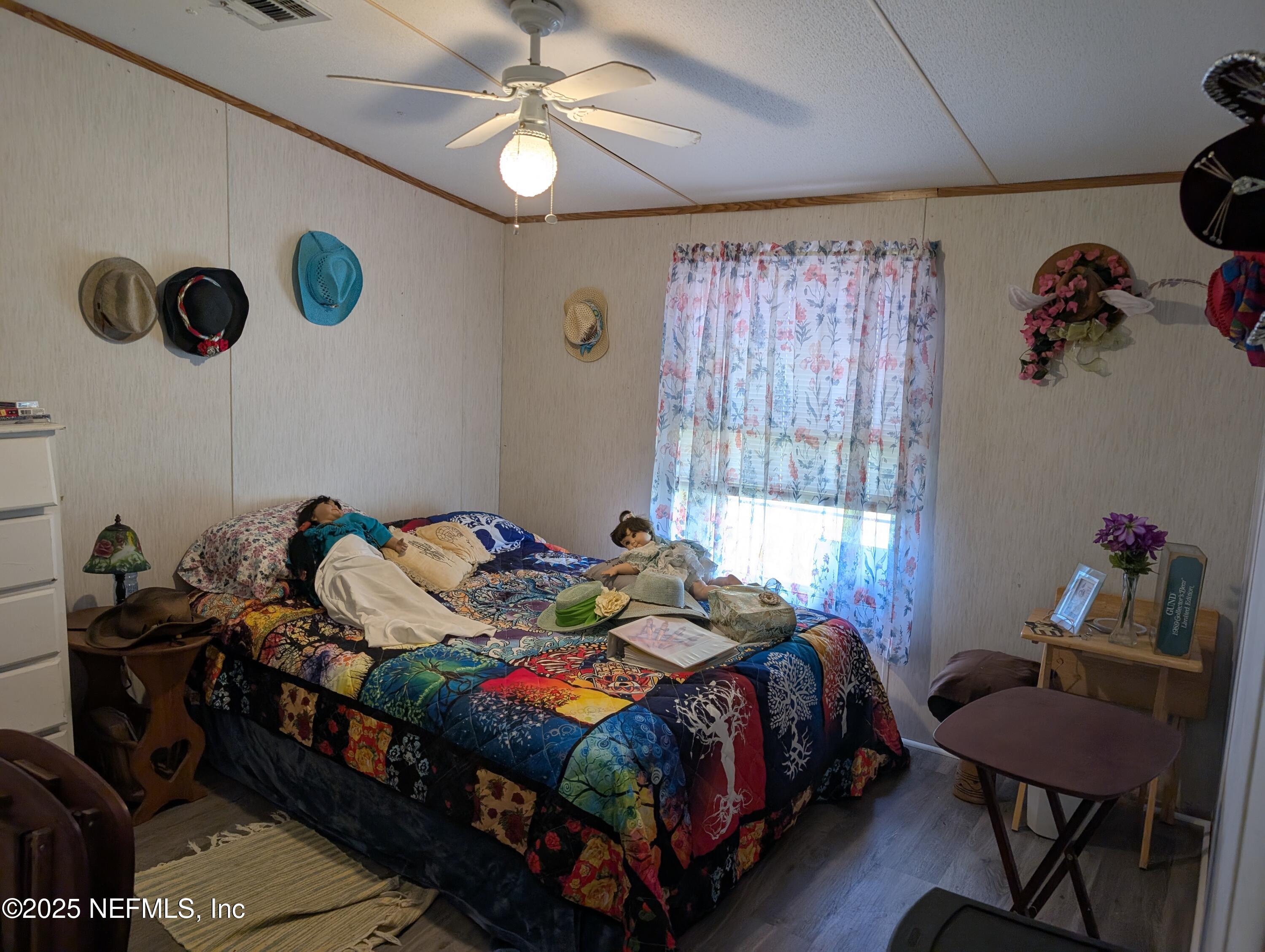 402 Shirley Street Interlachen, FL 32148 - Photo 10 of 20 a bedroom with a bed and a chandelier