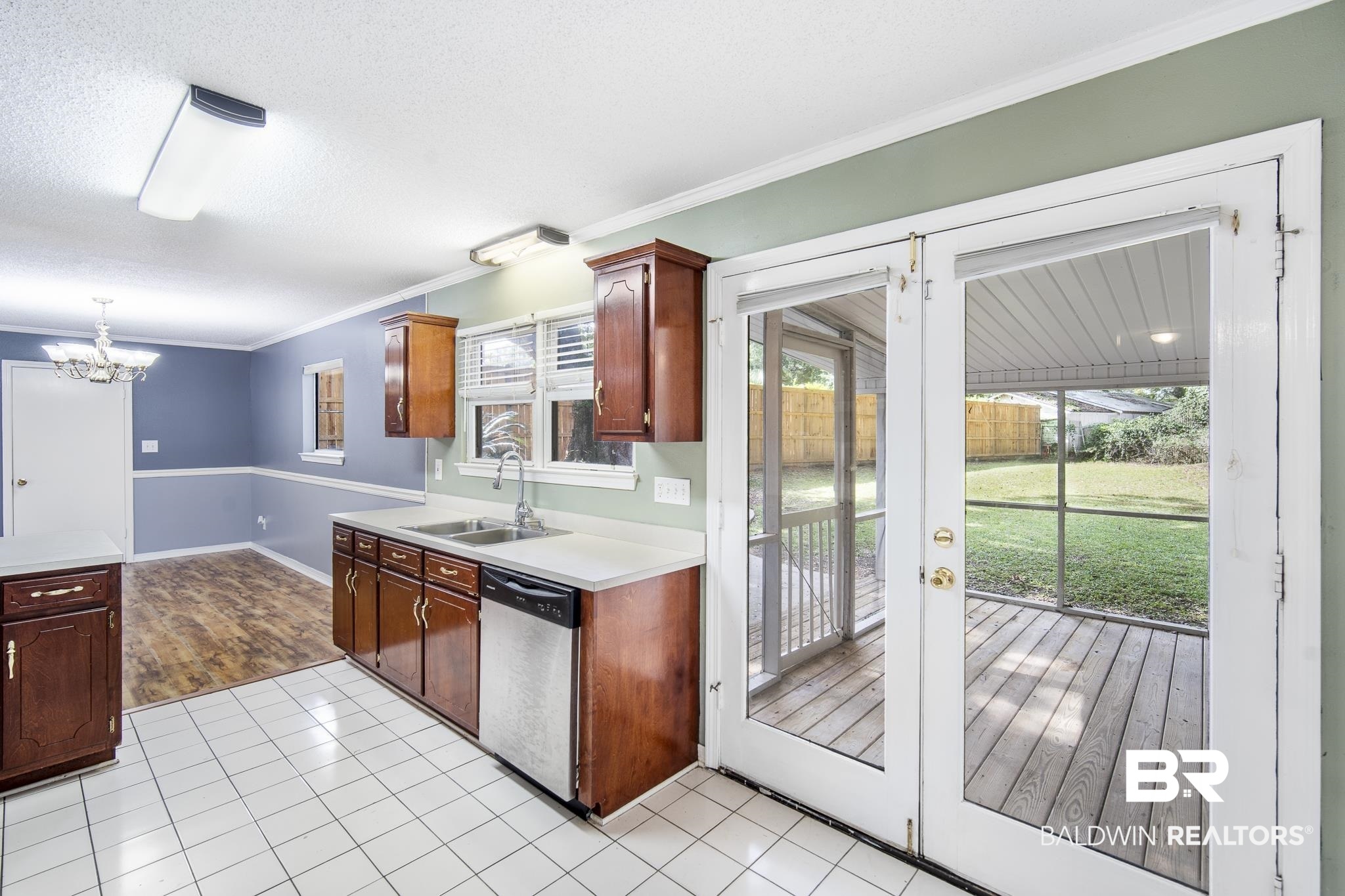 103 Ann Street Daphne, AL 36527 - Photo 8 of 23 Kitchen featuring ornamental molding, light countertops, stainless steel dishwasher, a textured ceiling, and light tile patterned floors